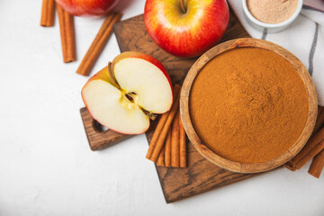 Apples with cinnamon on a textured wooden background. Fragrant red spiced apples with cinnamon sticks and star anise. Apple slices with spicy spices. Place for text. Copy space. Harvesting. Fruits.