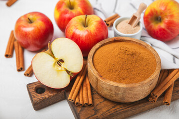 Apples with cinnamon on a textured wooden background. Fragrant red spiced apples with cinnamon sticks and star anise. Apple slices with spicy spices. Place for text. Copy space. Harvesting. Fruits.