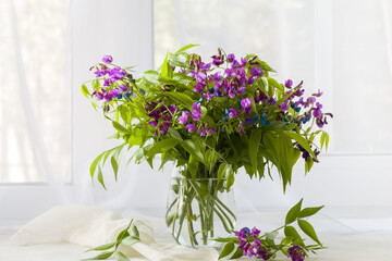 Spring bouquet in a white vase on a white windowsill