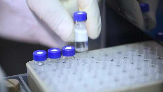 hplc close up, science experiment. vials filling inside an HPLC machine. inside view in a Science experimental laboratory for research development in instrumentation lab. HPLC machine filling vials