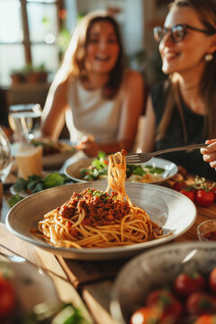 Happy group of friends eating pasta at home dinner party - Cheerful young people having lunch break together - Life style concept with guys and girls celebrating thanksgiving - Bright filter