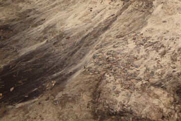  Background close-up a sandy surface.   Soil is washed away by the rain