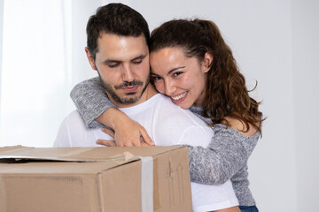 Happy couple packing their stuff to move into their new owned house. They are homeowners, mortgage concept. New home, new life