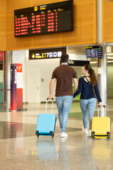 couple walking in the airport with their suitcases