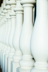 Selective focus side view of white painted newel posts in old porch railing, Saint-Augustin-de-Desmaures, Quebec, Canada