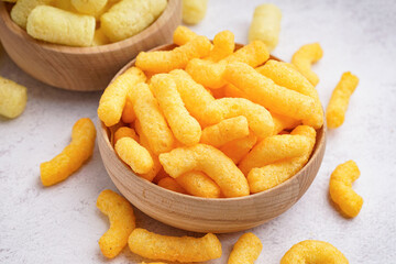 Wooden bowls with different tasty salty corn sticks on light background, closeup