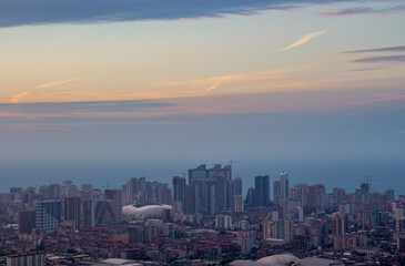 Fototapeta premium Sunset over city. Evening view of the port city. Skyscrapers on the coast.