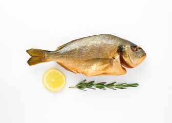 Smoked dorado fish sea breath on isolated white background close up top view decorated lemon slices, sprig of fresh rosemary. Omega3. Mediterranean seafood concept. Healthy food concept