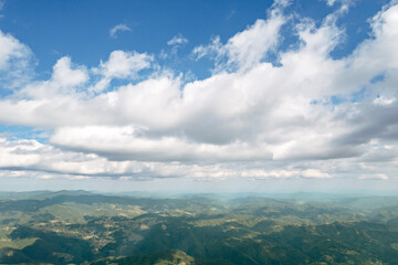 Moving white clouds blue sky scenic aerial view through summer. Drone slide turn flies forward high in blue sky through fluffy clouds on the panorama