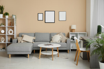 Stylish living room with comfortable sofa, coffee table, workplace and curtains