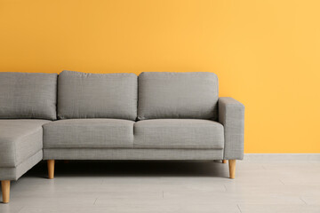 Cozy sofa near orange wall in stylish living room