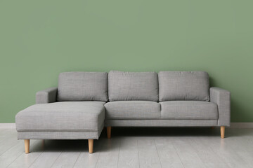 Cozy sofa near green wall in stylish living room