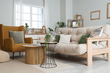 Stylish living room with brown armchair, coffee table, sofa and pillows
