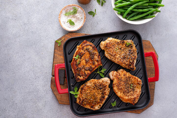 Grilled pork chops on a grill pan with herbs and spices