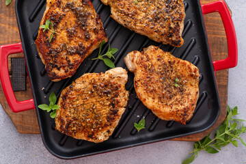 Grilled pork chops on a grill pan with herbs and spices