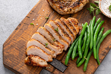 Grilled pork chop or chicken breast sliced on a cutting board