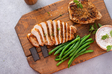 Grilled pork chop or chicken breast sliced on a cutting board