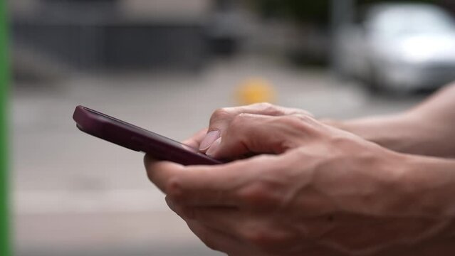 Close-up hands of unrecognizable man tapping smartphone screen to farming Hamster Combat cryptocurrency in mobile phone online application. Male extract crypto coins using smartphone, slow motion.