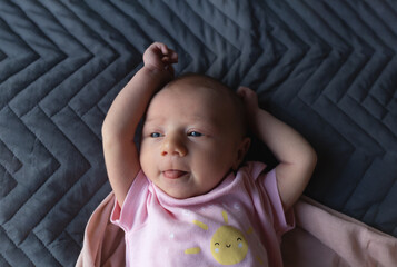 Sleeping newborn baby in a wrap on grey blanket. Beautiful portrait of little child girl