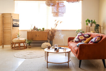 Interior of living room with sofa, plants and witch's magic attributes on table