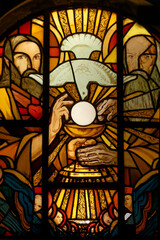 stained glass window depicting a dove of peace symbolizing the holy spirit bringing the eucharist.  vitrail moderne représentant une colombe de la paix apportant l’eucharistie