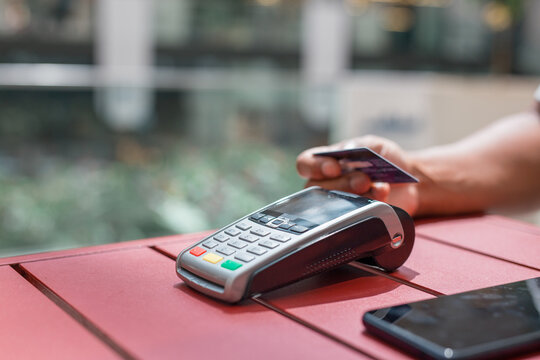 A person is using a credit card reader to pay for something