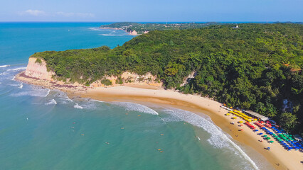 Aerial view of madeiro beach with umbrella beach at the coast, Pipa, Rio Grande do Norte, Brazil.