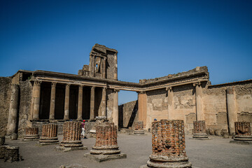 Ruins of ancient city of Pompeii, ancient roman city against Vesuvius volcano at sunset, Italy