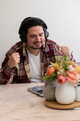 Man using headset and preparing to play and get fun with his laptop in the living room