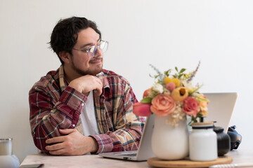 Happier man looking to the horizon while are using his laptot in the living room