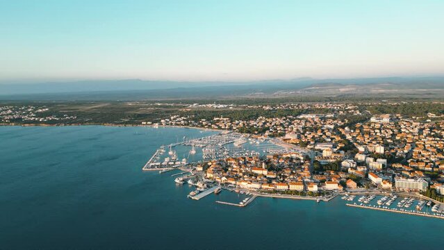 Biograd na Moru, marina aerial view, port with sailing boats and luxury yachts in sunlight. Summer landscape with Old Town houses and blue waters of Adriatic Sea coast, Dalmatia region in Croatia