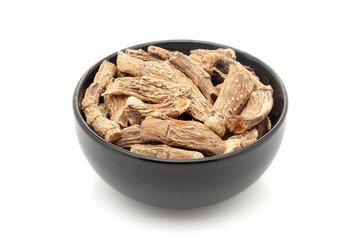 Close-up of Dry Organic Sweet flag or Vach (Acorus calamus) roots, in black ceramic bowl. Isolated on a white background.