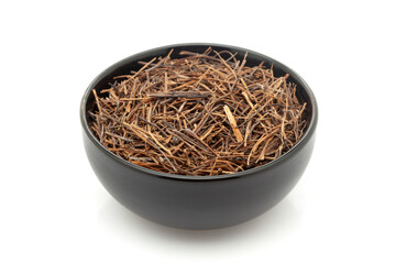 Close-up of Dry Organic Amar Bel (Cuscuta reflexa) roots, in black ceramic bowl. Isolated on a white background.