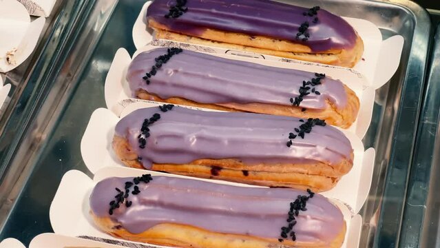 Lavender Glazed Eclairs with Black Sesame: A Stunning Bakery Display of Creamy Purple Choux Pastries