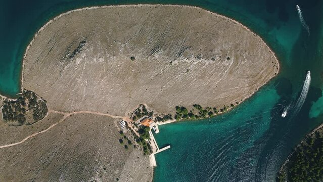 Drone view directly from above on island of Kornati archipelago with small houses and pier for boats, Croatia