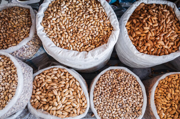 assortment of different varieties of almonds and pistachios in bags at the eastern Uzbek Chorsu bazaar in Tashkent in Uzbekistan