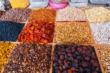 different varieties of dried fruits and nuts on the counter of oriental Asian food bazaar in Central Asia. Raisins, dried apricots, almonds, walnuts in market stall