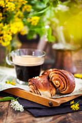 Homemade cinnamon and cardamom rolls (buns) and cup of black coffee