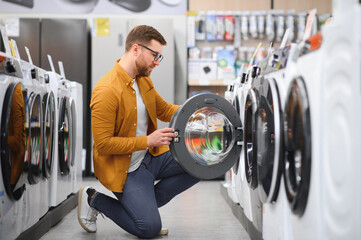 man choosing washing machine in showroom