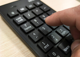 Mature mans hand pressing a numeric keypad