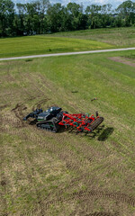 Autonomous agricultural robot equipped with soil-friendly crawler tracks and a attachment for ploughing of fields. Self-driving robot with autopilot using a GPS navigation system for smart farming.