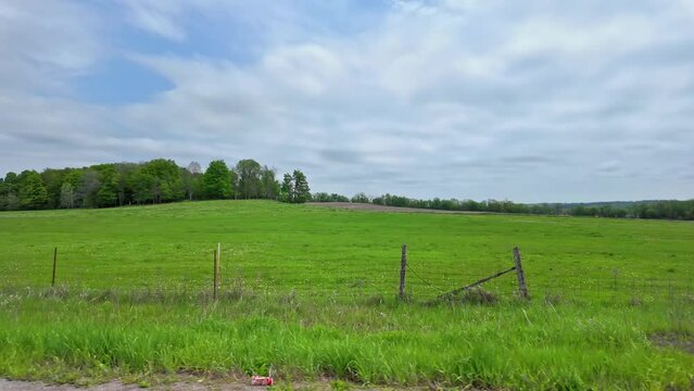 Wide view of farming fields at spring or early summer. Agriculture fields from the side window of the car while traveling in rural northern Ontario Canada.