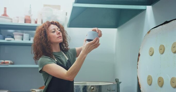 Ceramic Artist Inspecting Newly Fired Mugs