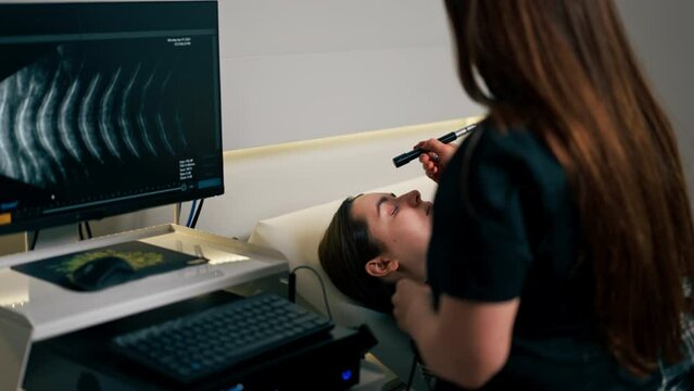 in an ophthalmology clinic young doctor performs an ultrasound of the eye of a young girl