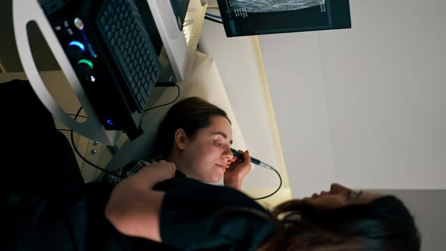 vertical video in an ophthalmology clinic young doctor performs an ultrasound of the eye of a young girl