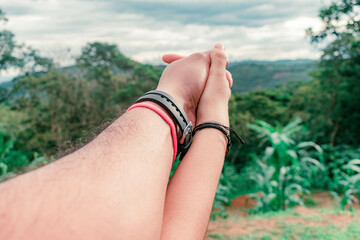 close-up of the intertwined hands of a man and woman couple