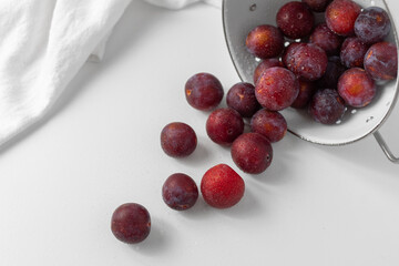 Top View of Red Plums on a White Countertop