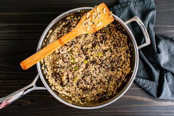 Mushroom Risotto in a Large Saute Pan with a Wooden Spatula: Freshly cooked risotto in a stainless steel saute pan with a bamboo spatula