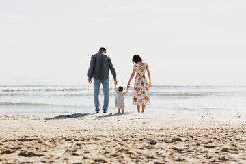 Serene Stroll: Family Walks Along Beach With Child