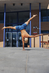 Urban Acrobatics: Man Handstanding by Building calisthenics